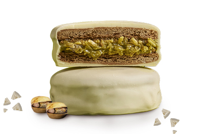 Alfajor-white-dubai Alfajor White Dubai cortado a la mitad, mostrando el relleno de pistacchio.